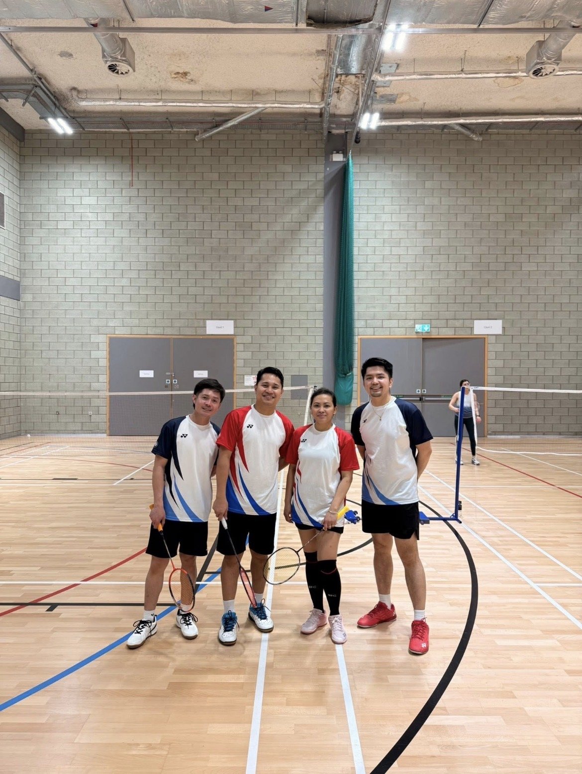 Four club members with their rackets on court